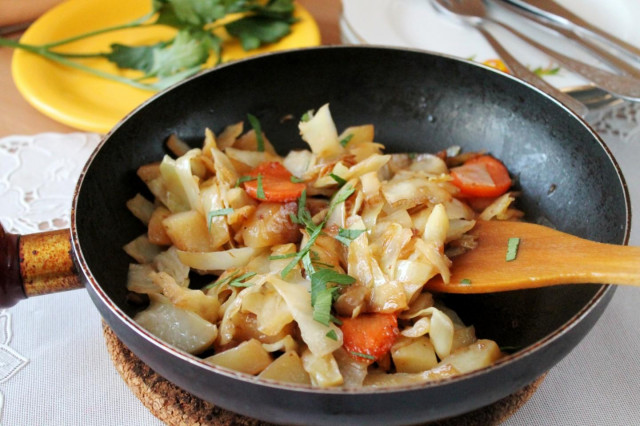 Cabbage and potatoes, fried onions and carrots in a frying pan