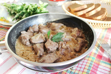 Roast turkey liver with onions in sour cream in a frying pan