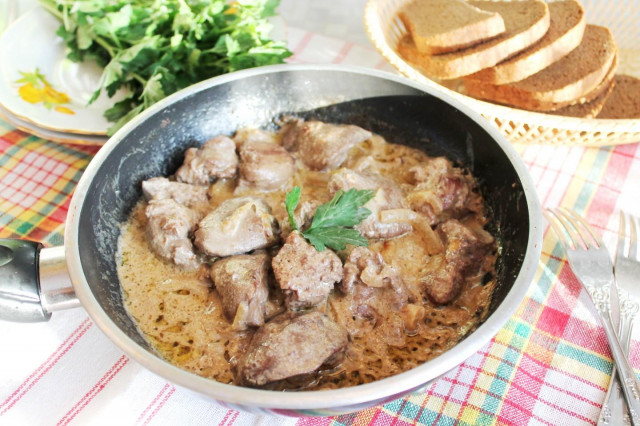 Roast turkey liver with onions in sour cream in a frying pan