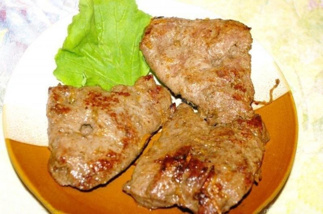 Fried veal liver with onions in a frying pan