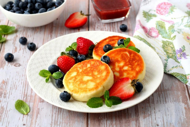 Cottage cheese pancakes with flour in a frying pan