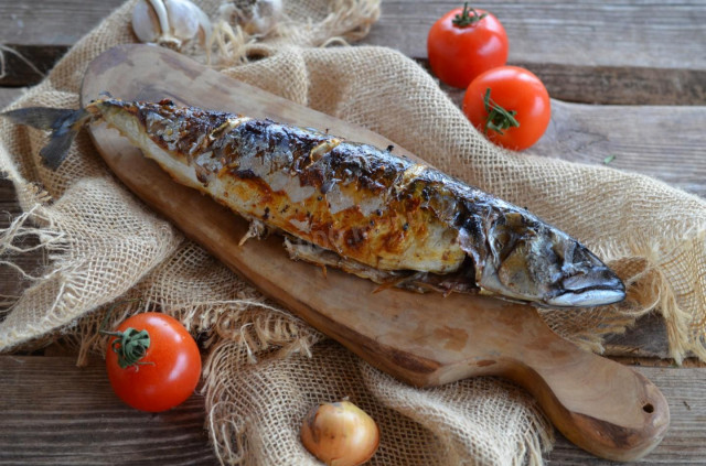 Grilled mackerel on a grill on coals in foil baked