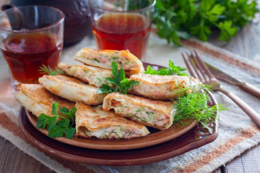 Pita bread with sausage and cheese in a frying pan