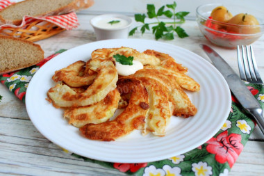 Zucchini in batter in a pan with garlic