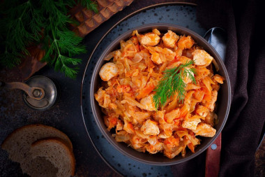 Stewed chicken breast with cabbage in a frying pan