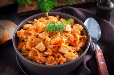 Stewed chicken breast with cabbage in a frying pan