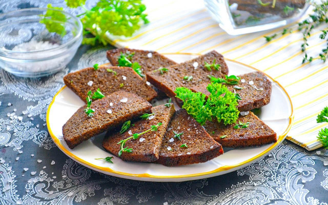 Black bread croutons with garlic in a frying pan