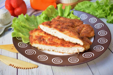 Breaded chicken schnitzel from breast in a frying pan