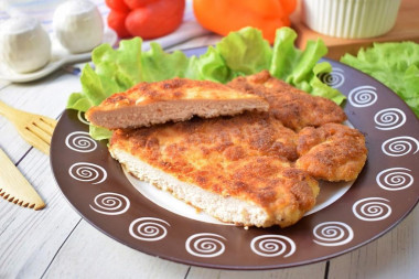 Breaded chicken schnitzel from breast in a frying pan