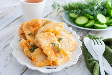 Pollock fillet in batter in a frying pan