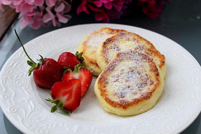 Tender cottage cheese cheesecakes with egg in a frying pan