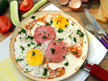 Fried eggs with sausage in a frying pan